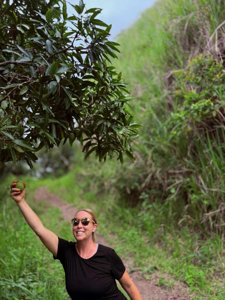 Kimberlee holding fresh fruit along a lush Jamaican path